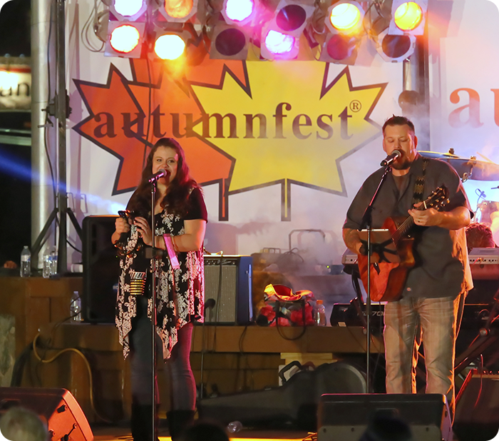 Two musicians performing at Autumnfest stage.